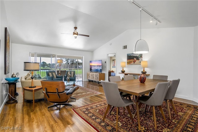 dining area with hardwood / wood-style floors, track lighting, ceiling fan, and lofted ceiling