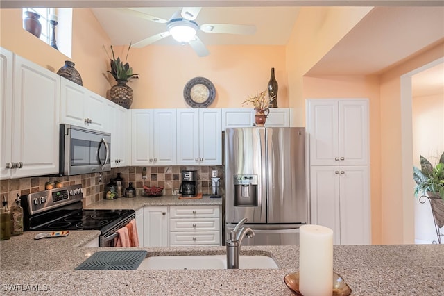 kitchen with sink, decorative backsplash, light stone counters, white cabinetry, and stainless steel appliances