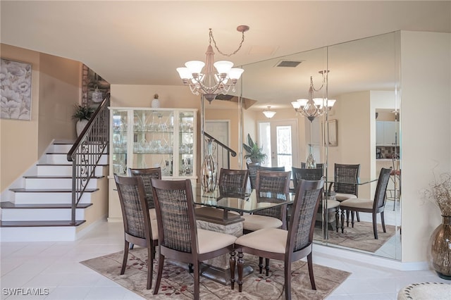 dining area with light tile patterned floors and an inviting chandelier