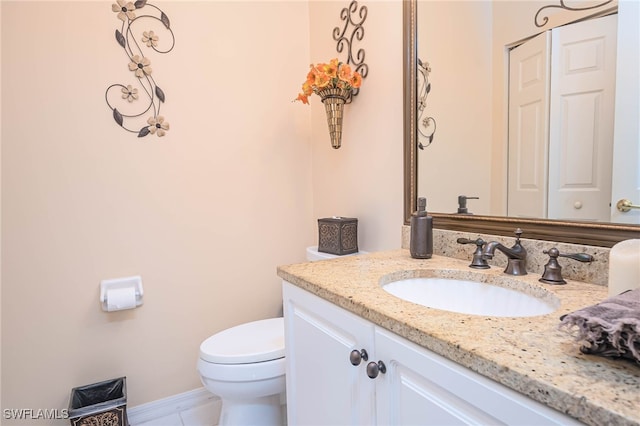 bathroom featuring tile patterned flooring, vanity, and toilet