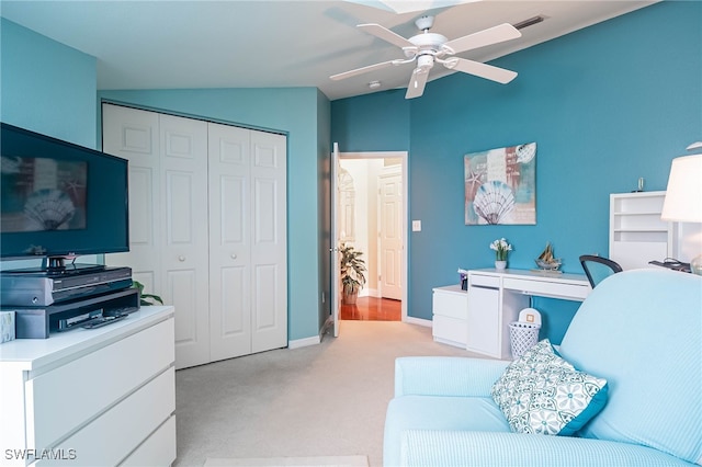 interior space with ceiling fan, light colored carpet, and vaulted ceiling