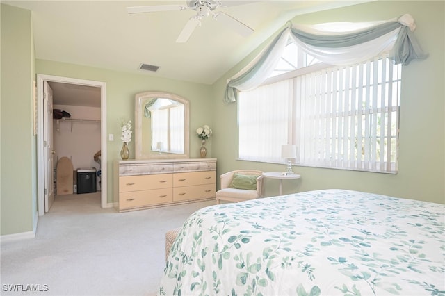 carpeted bedroom with ceiling fan, a spacious closet, and a closet