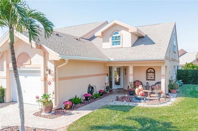 view of front of home featuring a garage, covered porch, and a front lawn