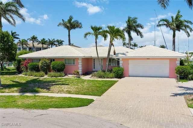 ranch-style house featuring a garage and a front yard