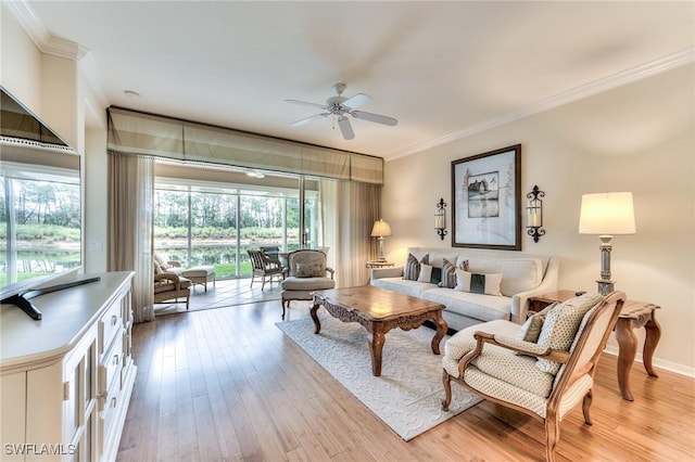 living room featuring ceiling fan, light wood-type flooring, and ornamental molding