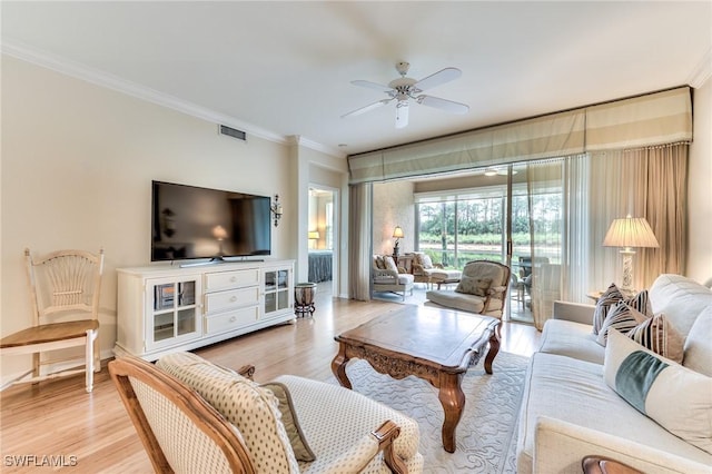 living room with ceiling fan, ornamental molding, and light hardwood / wood-style flooring