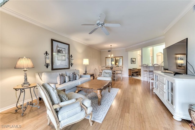 living room with ceiling fan with notable chandelier, crown molding, and light hardwood / wood-style flooring