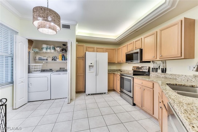 kitchen featuring light brown cabinets, an inviting chandelier, independent washer and dryer, appliances with stainless steel finishes, and decorative light fixtures