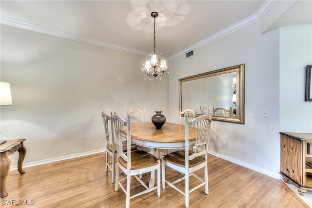 dining space with an inviting chandelier, ornamental molding, and light hardwood / wood-style flooring