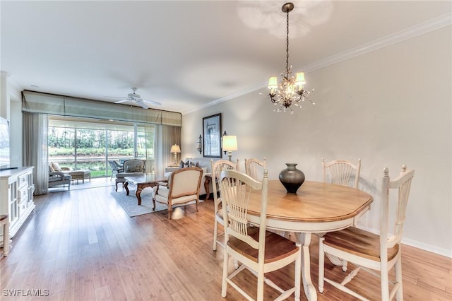 dining space featuring ceiling fan with notable chandelier, light wood-type flooring, and ornamental molding