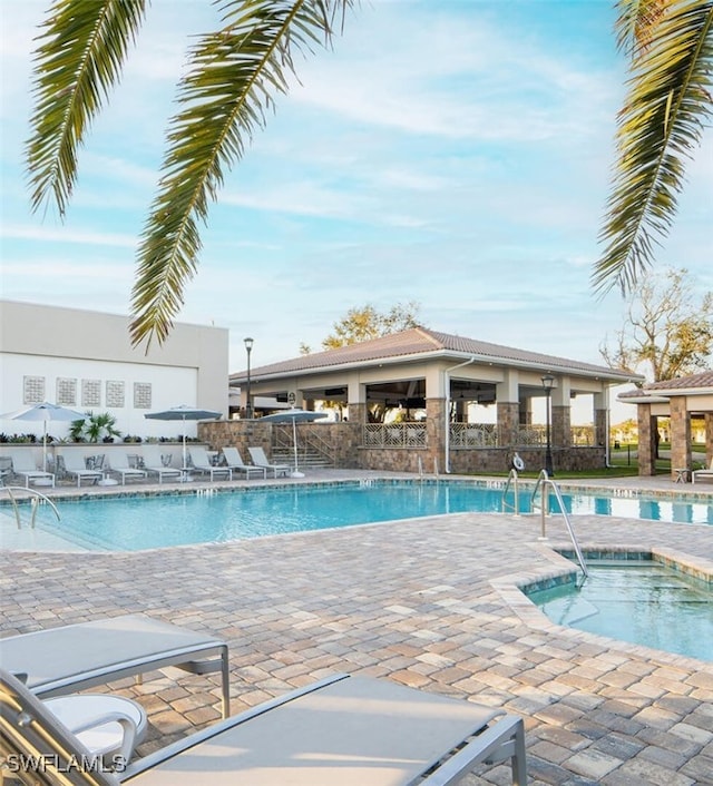 view of pool with a patio and a hot tub