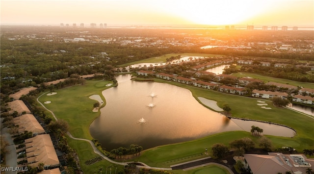 aerial view at dusk featuring a water view