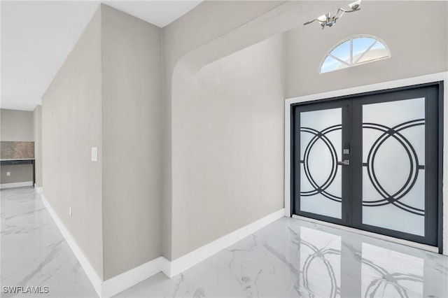 entryway with an inviting chandelier and french doors