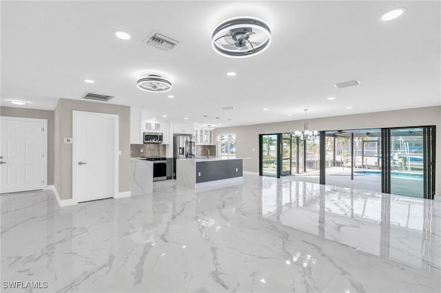 unfurnished living room featuring a notable chandelier and sink