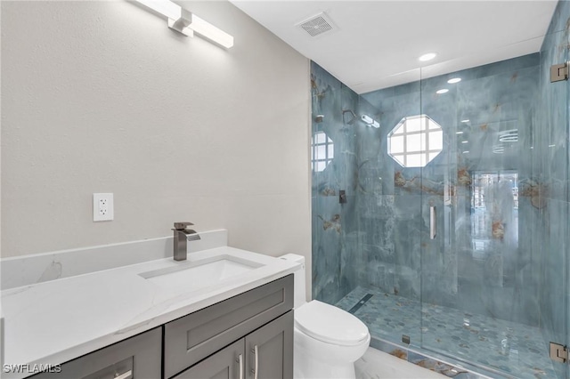 bathroom with vanity, toilet, and a shower with shower door