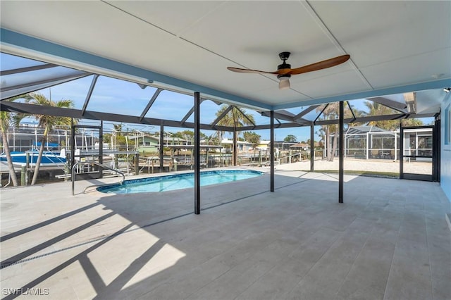 view of swimming pool with glass enclosure and a patio