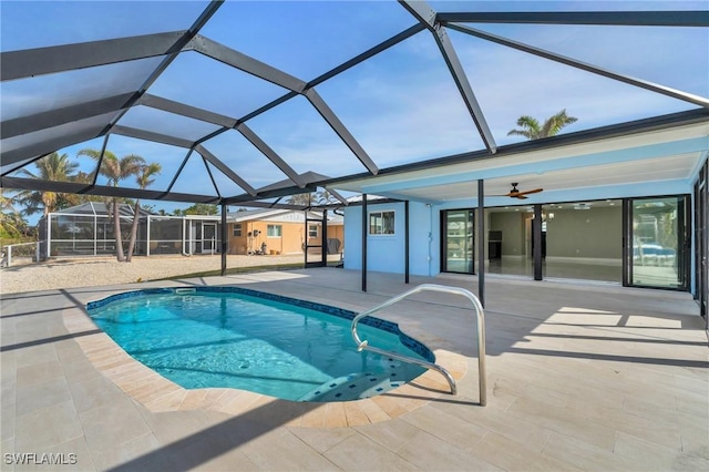 view of pool featuring glass enclosure, ceiling fan, and a patio