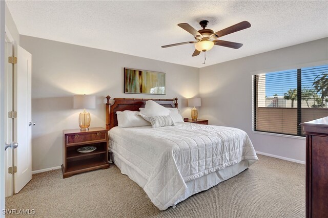 bedroom featuring baseboards, a textured ceiling, and light colored carpet