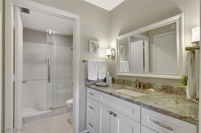 full bathroom featuring toilet, visible vents, vanity, tile patterned floors, and a stall shower