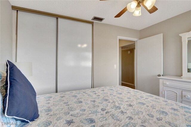 bedroom featuring ceiling fan, visible vents, and a closet