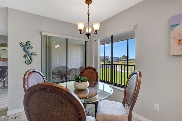 dining room featuring a chandelier, light wood finished floors, and baseboards