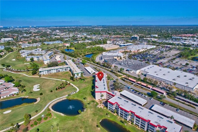 drone / aerial view with golf course view and a water view