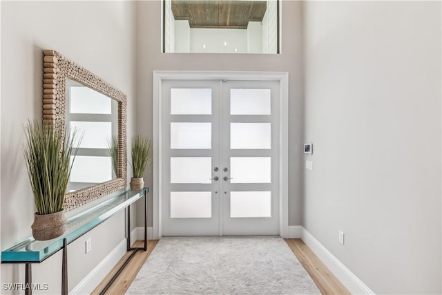 entryway with french doors, a healthy amount of sunlight, and light wood-type flooring