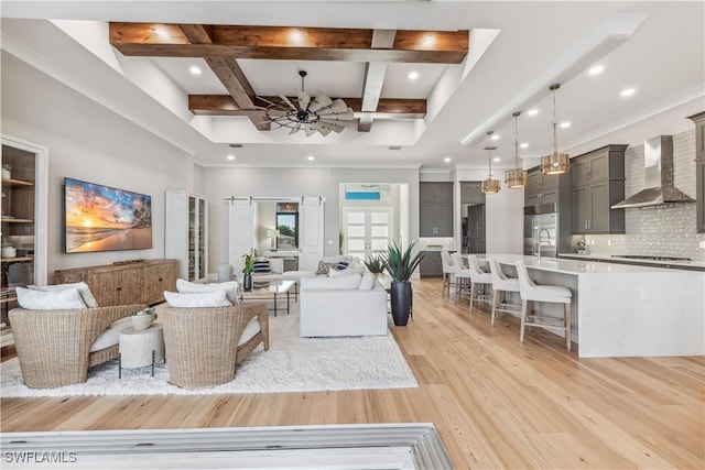 living room with sink, light hardwood / wood-style flooring, ceiling fan, coffered ceiling, and beamed ceiling