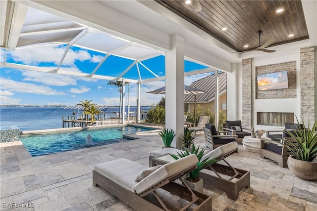 view of patio with ceiling fan, an outdoor living space, glass enclosure, and a water view