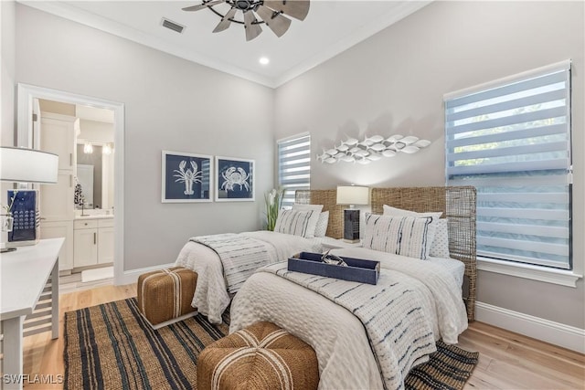 bedroom featuring ensuite bath, light hardwood / wood-style flooring, ornamental molding, and ceiling fan