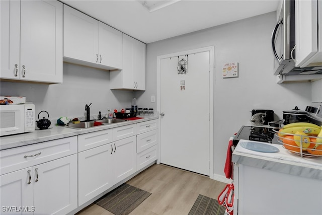 kitchen featuring light hardwood / wood-style floors, white cabinetry, and sink