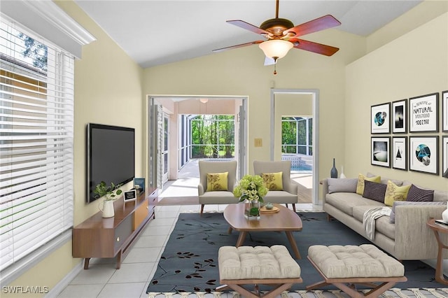 living room with ceiling fan, light tile patterned flooring, and lofted ceiling