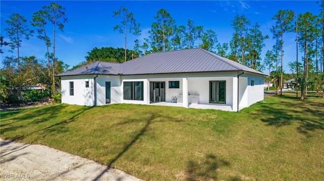 rear view of property featuring a lawn and a patio