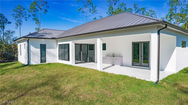 rear view of property featuring a lawn and a patio