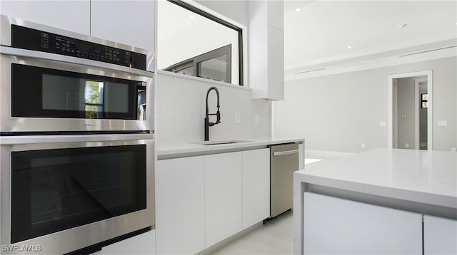 kitchen featuring white cabinets, sink, and appliances with stainless steel finishes