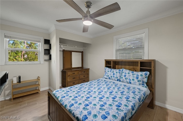 bedroom with ceiling fan, crown molding, and light hardwood / wood-style floors