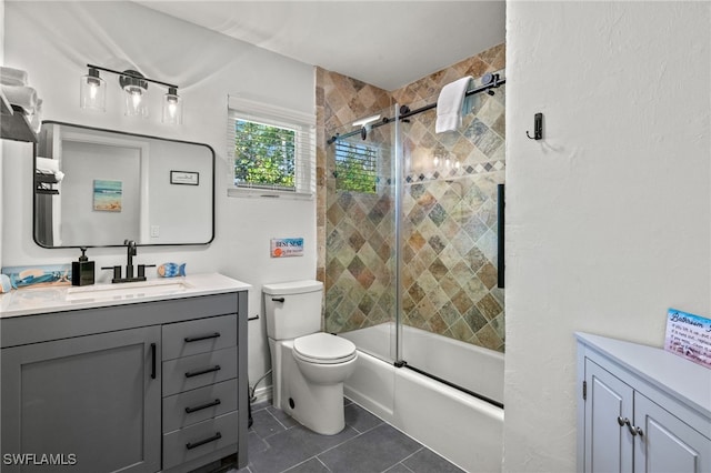 full bathroom featuring tile patterned floors, vanity, bath / shower combo with glass door, and toilet