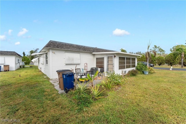 back of property with a yard and a patio