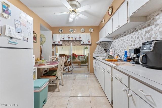 kitchen with tasteful backsplash, ceiling fan, white refrigerator, white cabinets, and light tile patterned flooring