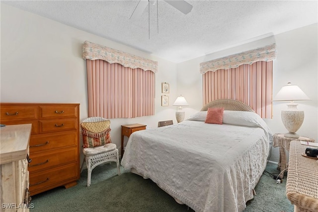 bedroom with ceiling fan, dark carpet, and a textured ceiling