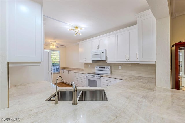 kitchen featuring backsplash, white appliances, ceiling fan, sink, and white cabinets