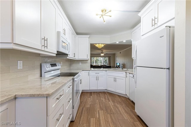 kitchen featuring light wood-type flooring, white appliances, ceiling fan, sink, and white cabinetry