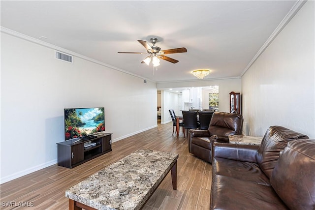 living room featuring ceiling fan, wood-type flooring, and ornamental molding