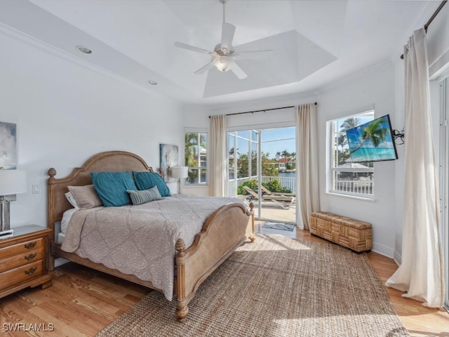 bedroom with access to outside, a raised ceiling, ceiling fan, and light hardwood / wood-style floors