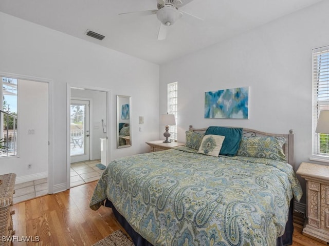 bedroom with access to exterior, hardwood / wood-style flooring, multiple windows, and ceiling fan