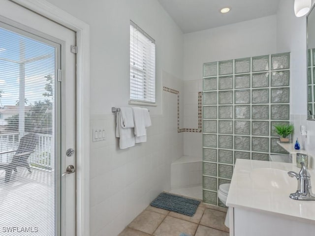 bathroom with tile patterned flooring, vanity, tile walls, and toilet