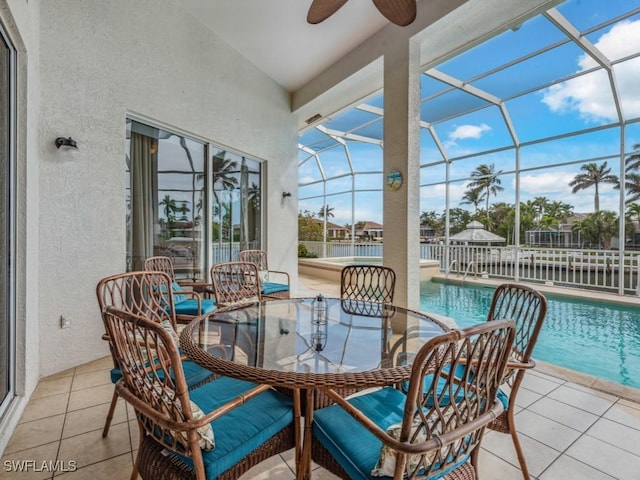 sunroom / solarium featuring a water view, ceiling fan, and a swimming pool