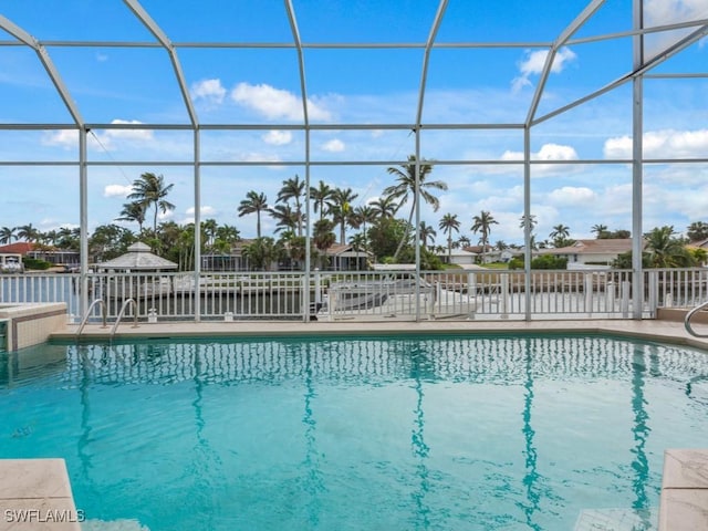 view of pool with glass enclosure and a patio area