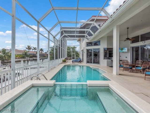 view of swimming pool featuring a patio, a water view, glass enclosure, and ceiling fan