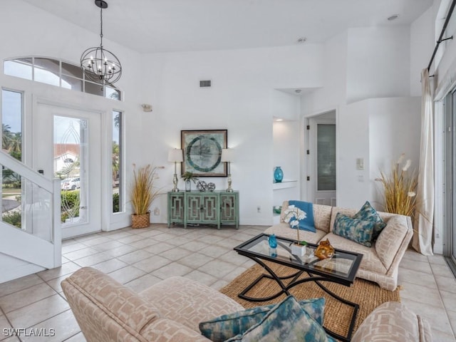 living room featuring a high ceiling, light tile patterned floors, and a notable chandelier